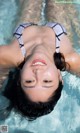 A woman in a bikini floating in a pool.