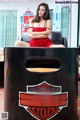 A woman in a red dress sitting on a black chair.