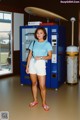 A woman standing in front of a vending machine.