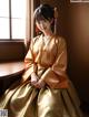 A woman in a kimono sitting on a window sill.