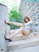 A woman is sitting on the steps of a building.