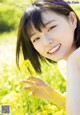 A young woman in a field of yellow flowers.