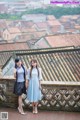 A couple of women standing next to each other on a balcony.