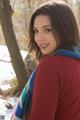 A young woman wearing a red sweater and a blue and white scarf.